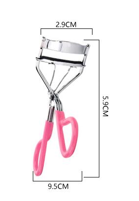 Metal eyelash curler held in hand for size reference